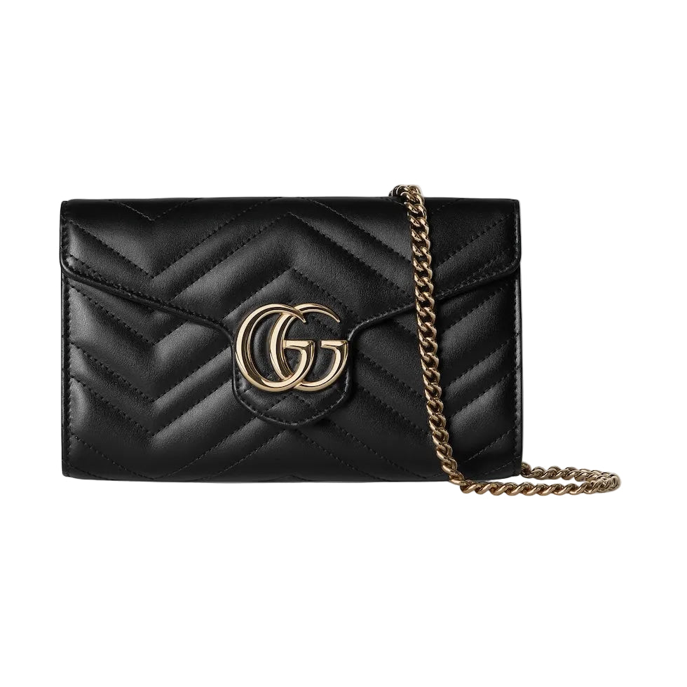 Black quilted handbag with gold chain and logo on a light gray background