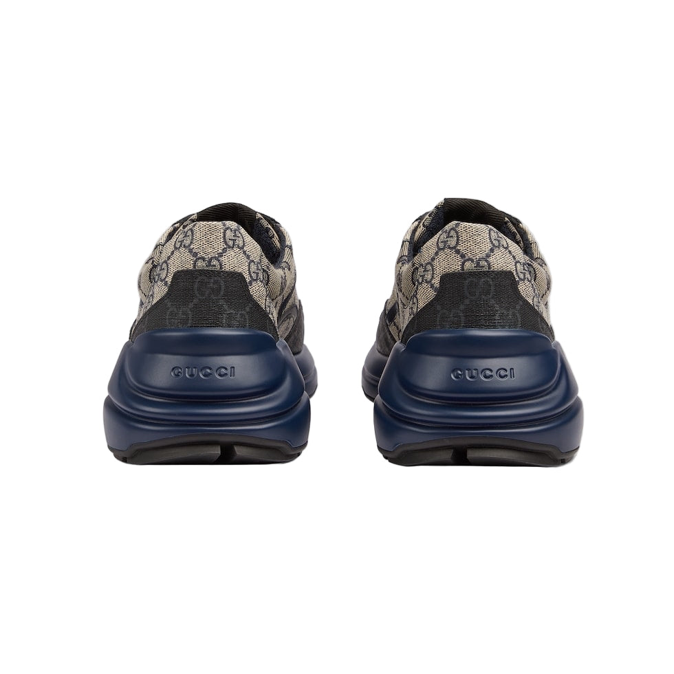 Pair of Gucci sneakers with blue soles on a light gray background