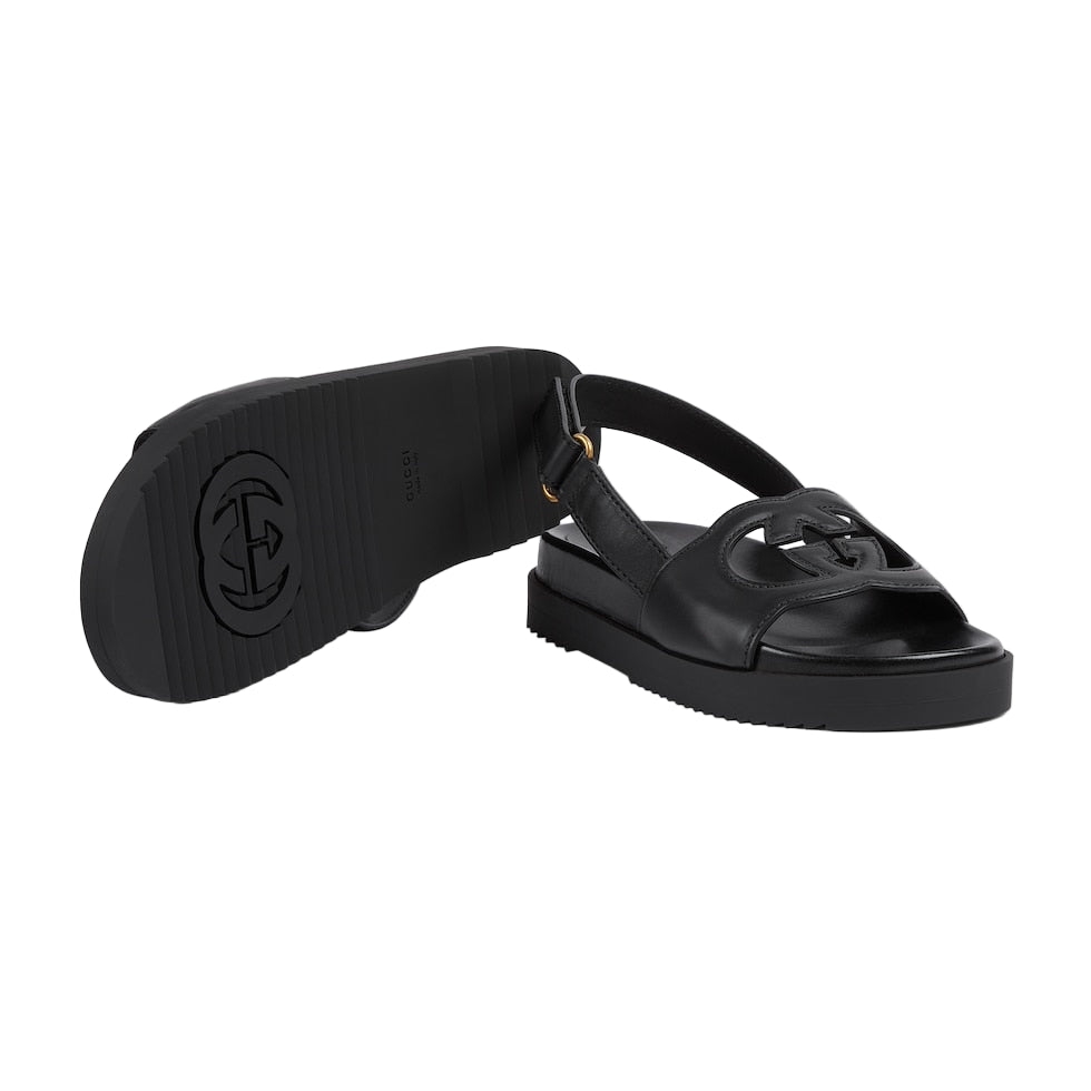 Black sandal with a logo on a light gray background