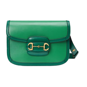 Green Gucci Horsebit handbag with gold clasp on a light gray background