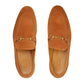 Pair of tan suede loafers with gold buckles on a light gray background