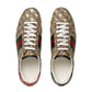 Pair of Gucci sneakers with patterned design and white laces on a light gray background