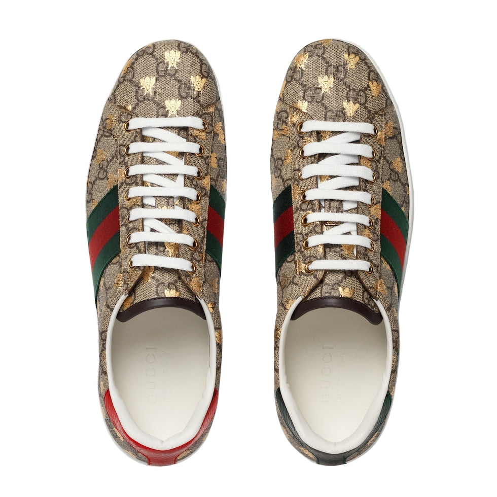 Pair of Gucci sneakers with patterned design and white laces on a light gray background