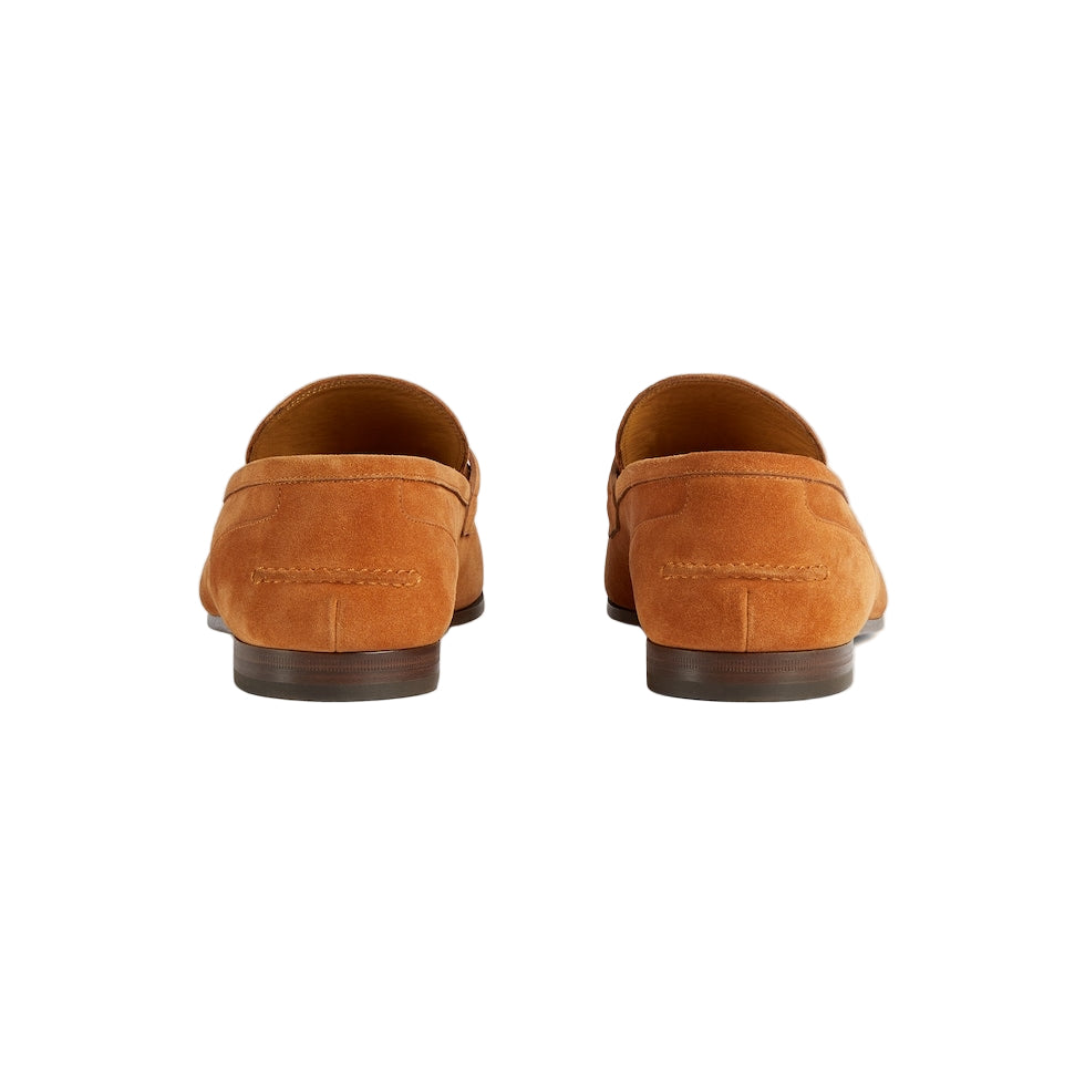 Pair of brown suede loafers on a light gray background