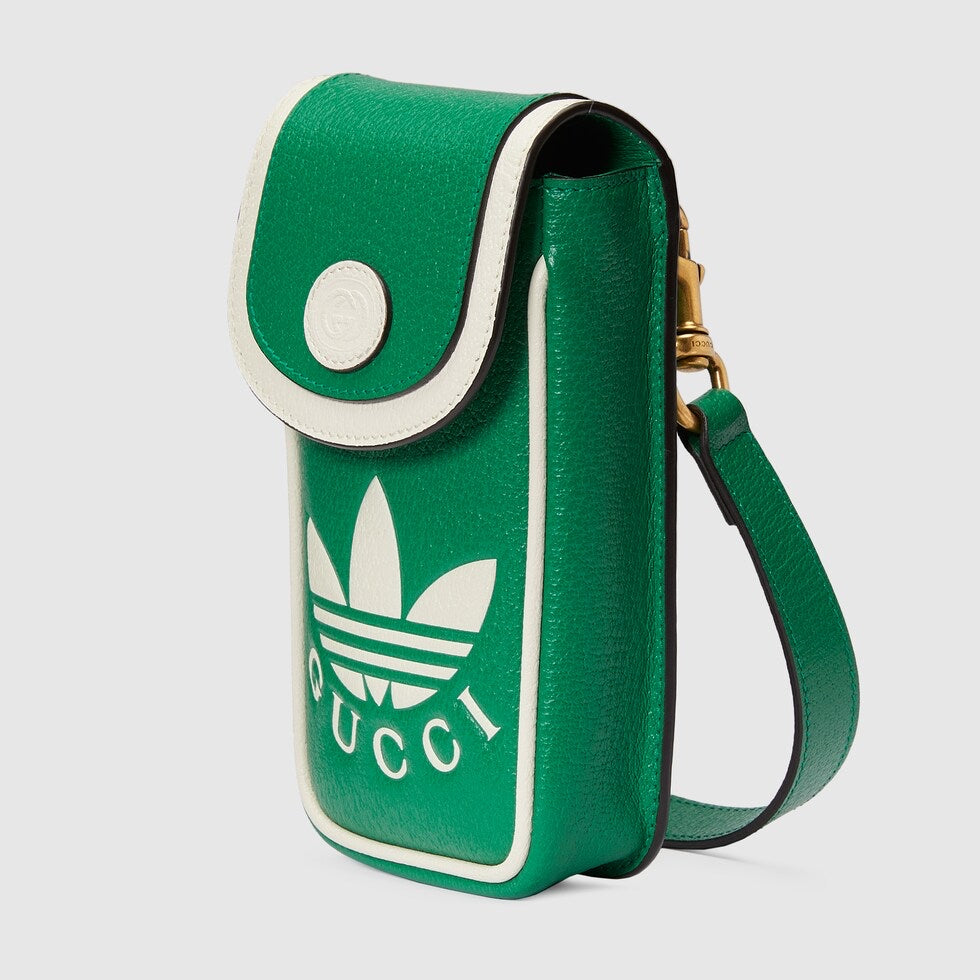 Green crossbody bag with Gucci logo on a light gray background