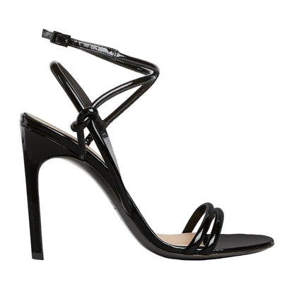 Black high-heeled sandal with thin straps on a light gray background