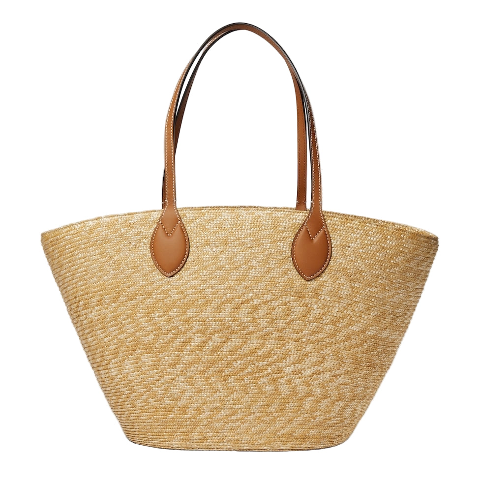 Woven straw tote bag with brown leather handles on a light gray background