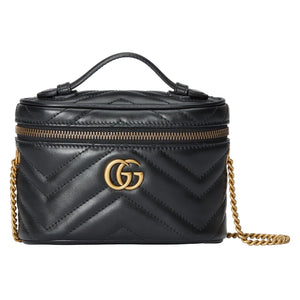Black quilted Gucci handbag with gold chain and logo on a light gray background