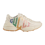 Beige sneaker with colorful 'Gucci' logo on a light gray background