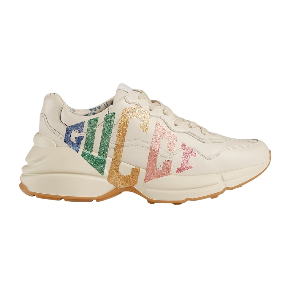 Beige sneaker with colorful 'Gucci' logo on a light gray background
