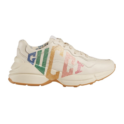 Beige sneaker with colorful 'Gucci' logo on a light gray background