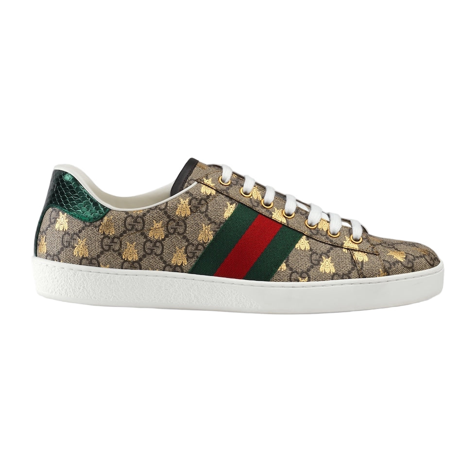 Gucci sneaker with patterned design and iconic green and red stripe on a light gray background