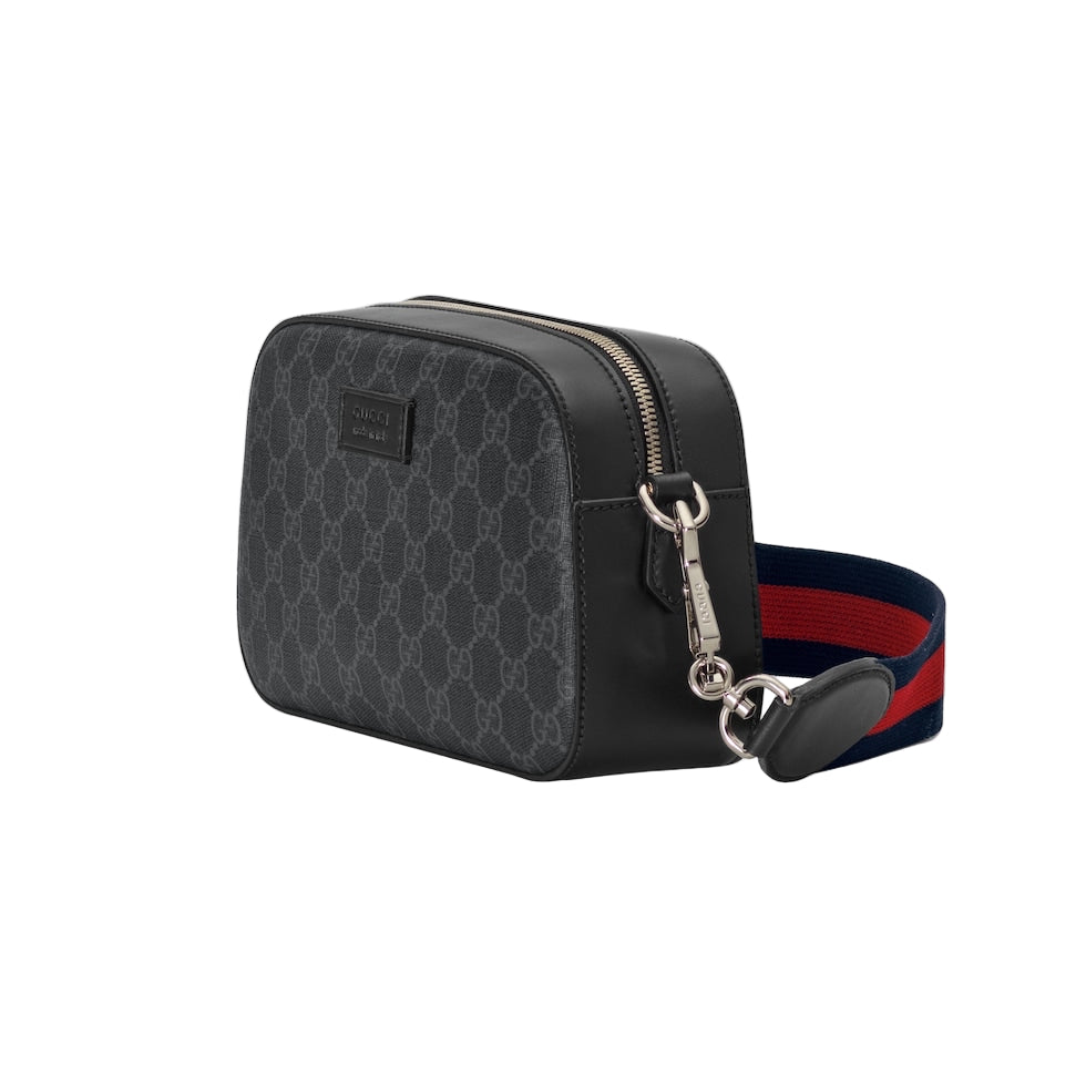 Black patterned bag with a strap on a light gray background
