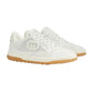 White sneakers with a brand logo on a light gray background