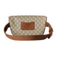 Gucci belt bag with brown strap on a light gray background