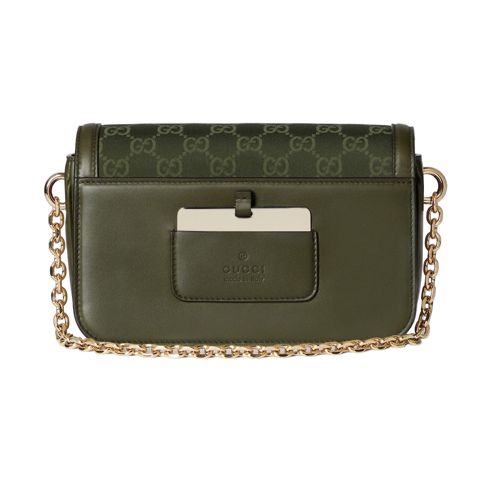 Green handbag with gold chain on a light gray background