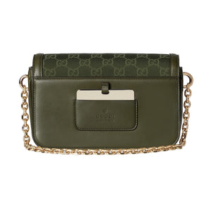 Green handbag with gold chain on a light gray background
