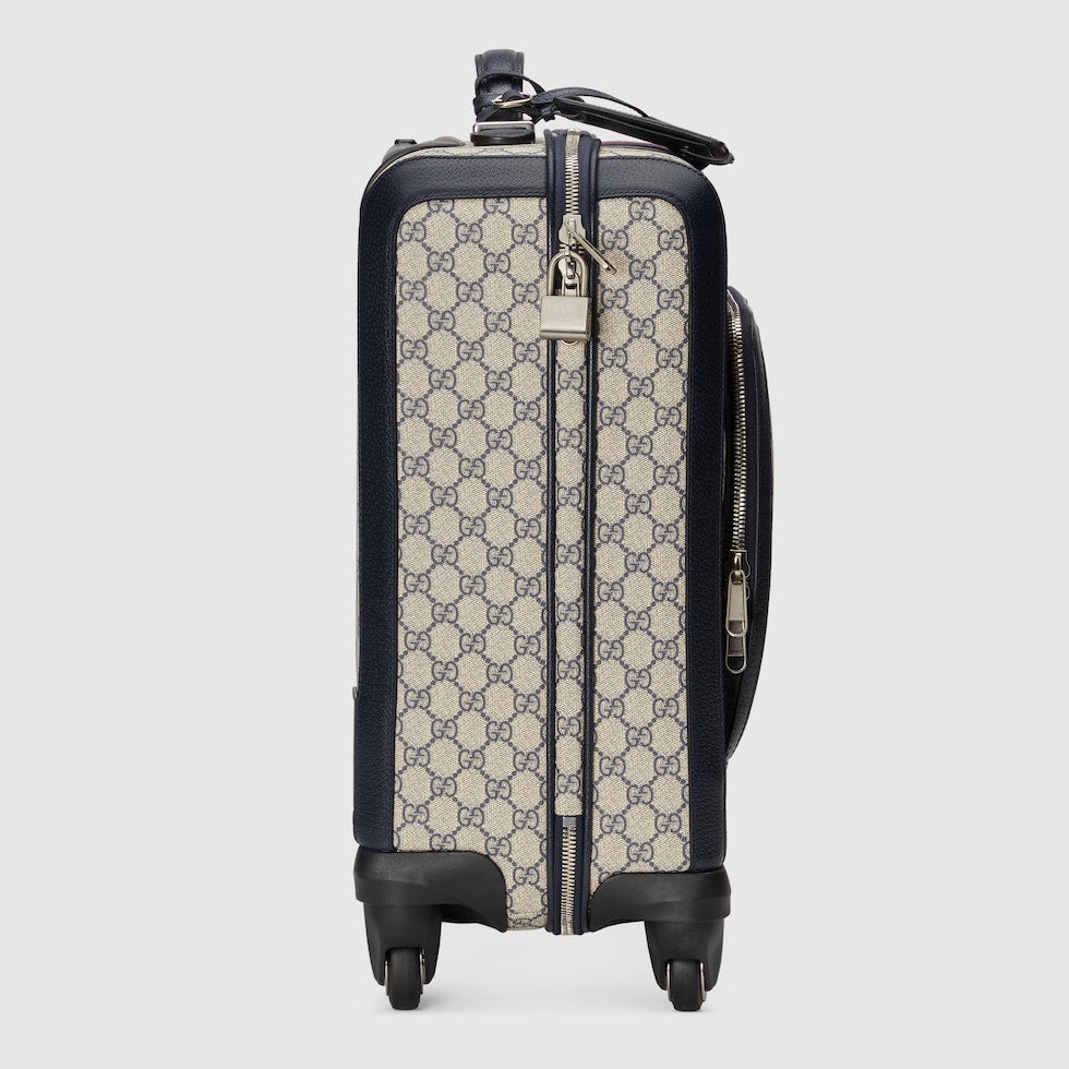 Patterned suitcase with black accents on a light gray background
