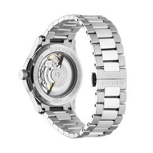 Silver Gucci automatic watch with open face on a light gray background