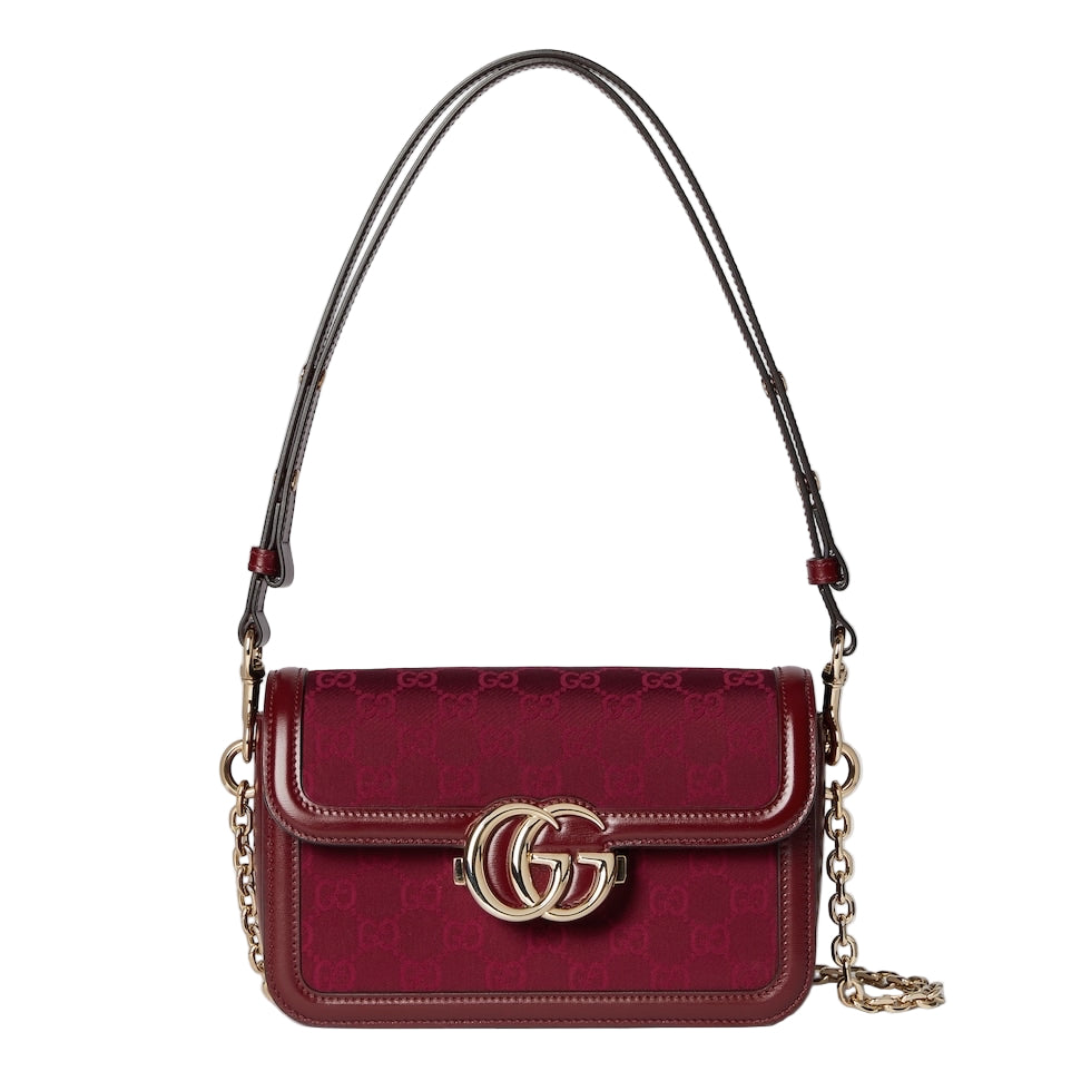 Red handbag with gold chain and logo on a light gray background