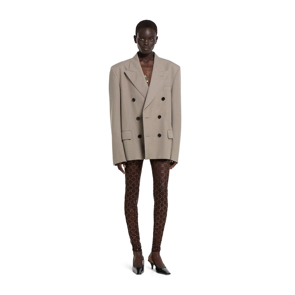 Person wearing a beige double-breasted blazer on a white background
