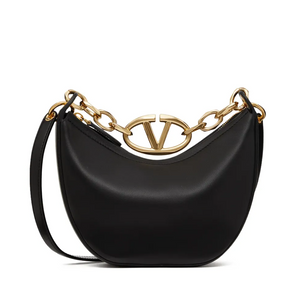 Black handbag with gold chain detail on a white background