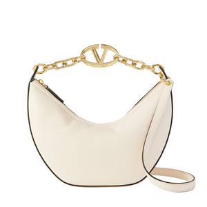 White handbag with gold chain handle on a light gray background
