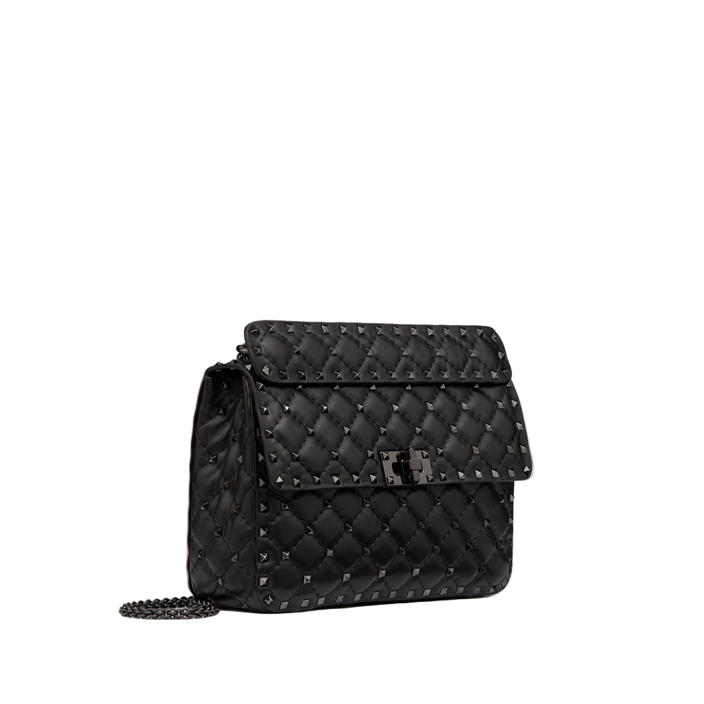Black quilted handbag with chain detail on a light gray background