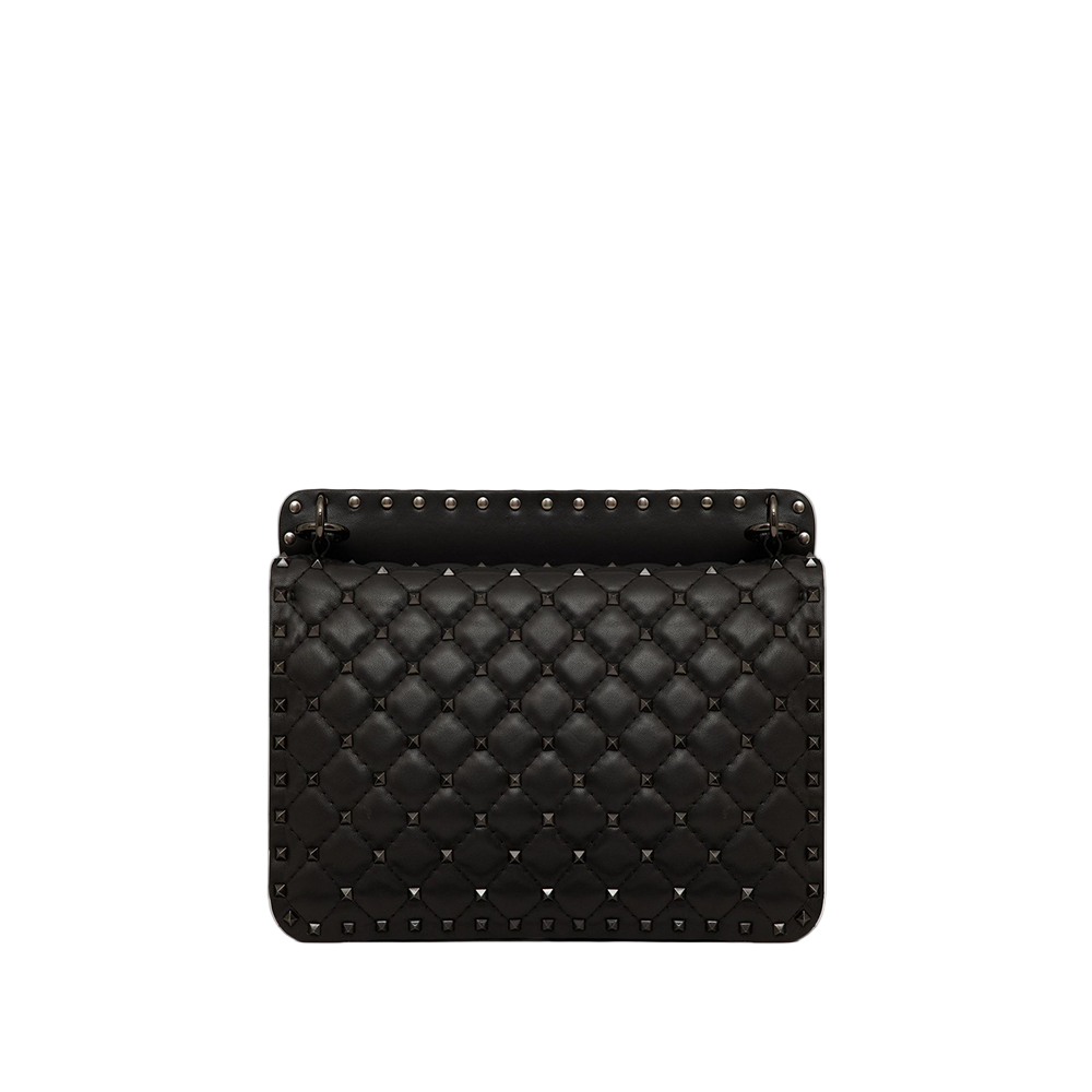 Black quilted handbag with studs on a light gray background