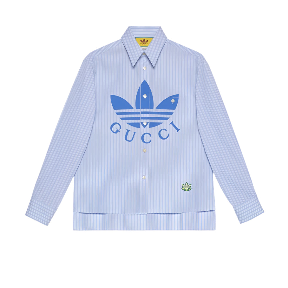 Light blue striped shirt with Gucci and Adidas logos on a light gray background