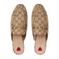 Pair of Gucci loafers with monogram pattern and gold hardware on a light gray background