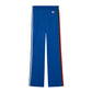 Blue track pants with red and white stripes on a light gray background