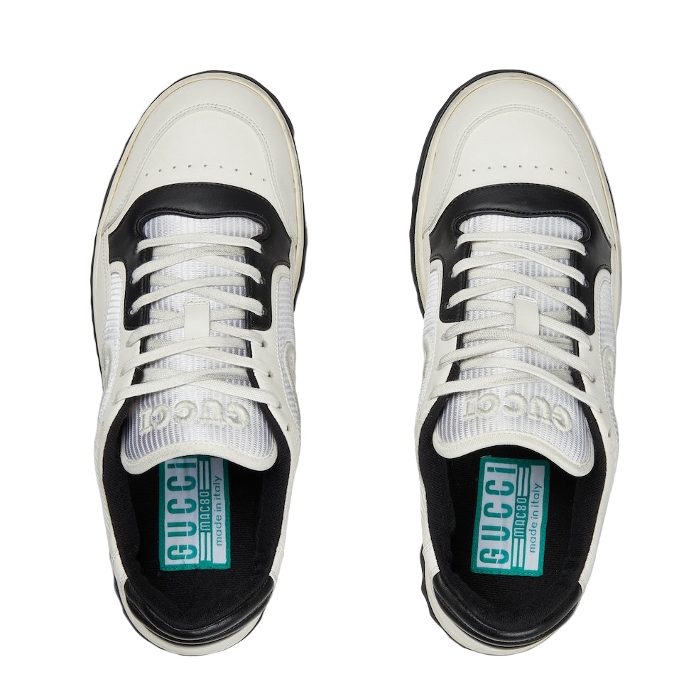 White sneakers with black accents and Gucci logo on a white background