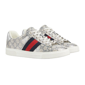 Pair of Gucci sneakers with a patterned design and red and blue stripe on a light gray background