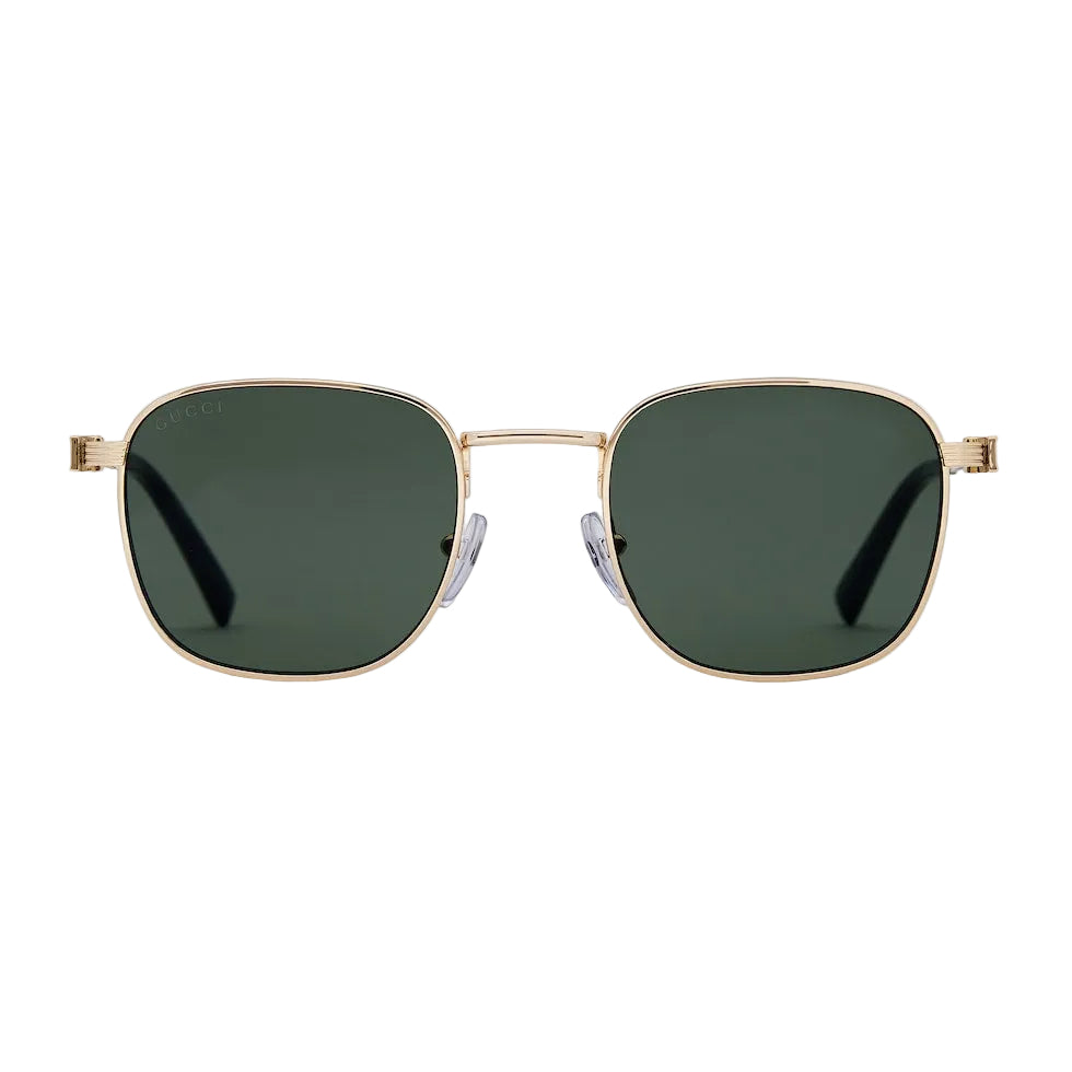 Gold-framed sunglasses with green lenses on a light gray background