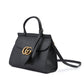 Black handbag with a gold Gucci logo on a white background