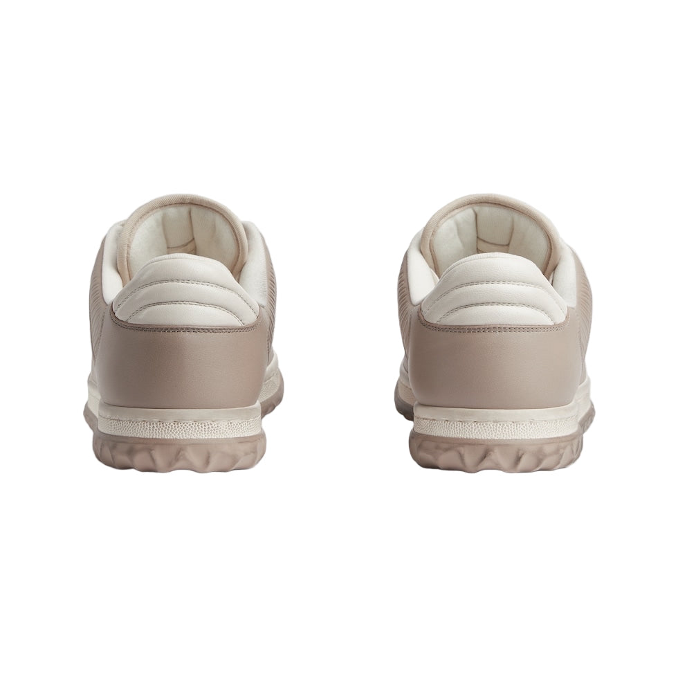 Pair of beige sneakers on a light gray background