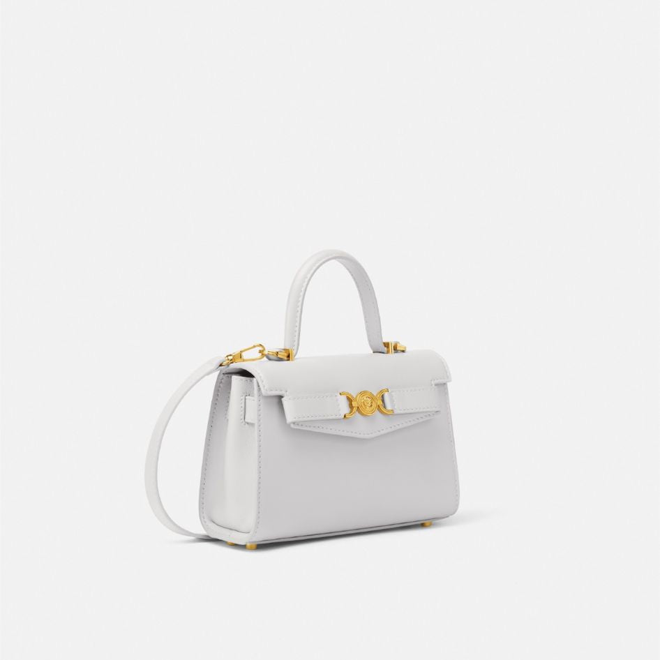 White handbag with gold accents on a white background
