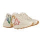 Beige sneakers with colorful 'Gucci' branding on a light gray background