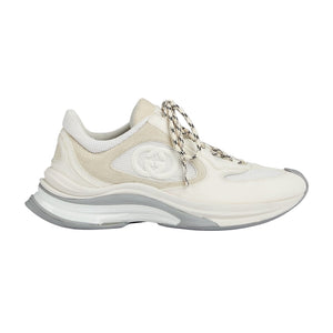 White sneaker with chain detail on a light gray background