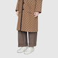 Person wearing a brown patterned coat with matching pants on a white background