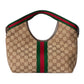Beige handbag with Gucci logo and red and green stripes on a light gray background