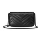 Black quilted handbag with chain strap on a light gray background