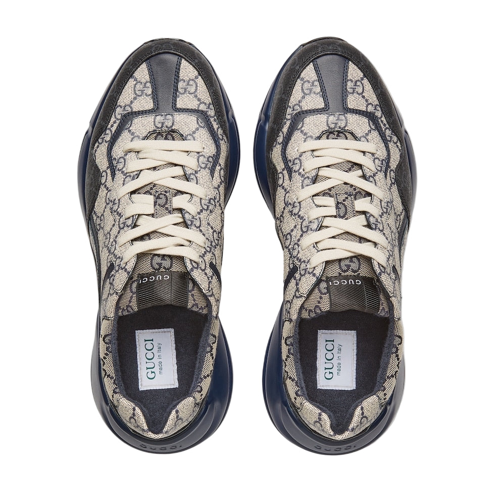 Pair of Gucci sneakers with patterned design on a light gray background