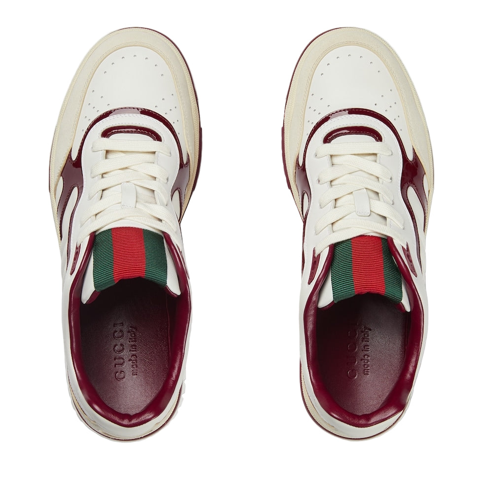 White sneakers with red and green accents on a white background