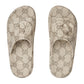 Pair of Gucci patterned slippers on a light gray background