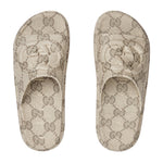 Pair of Gucci patterned slippers on a light gray background
