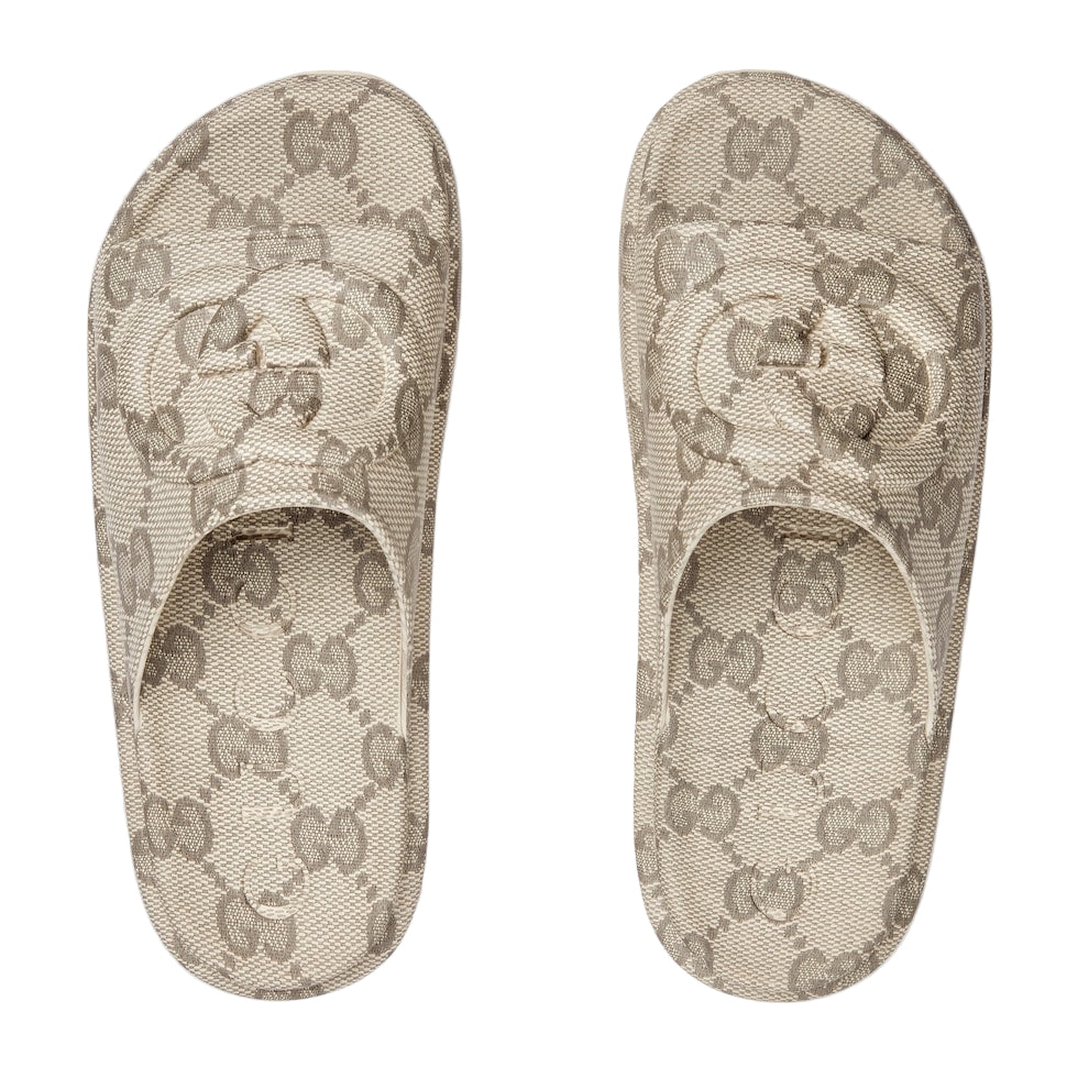 Pair of Gucci patterned slippers on a light gray background