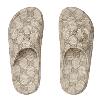 Pair of Gucci patterned slippers on a light gray background