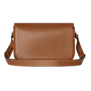 Brown leather shoulder bag on a light gray background